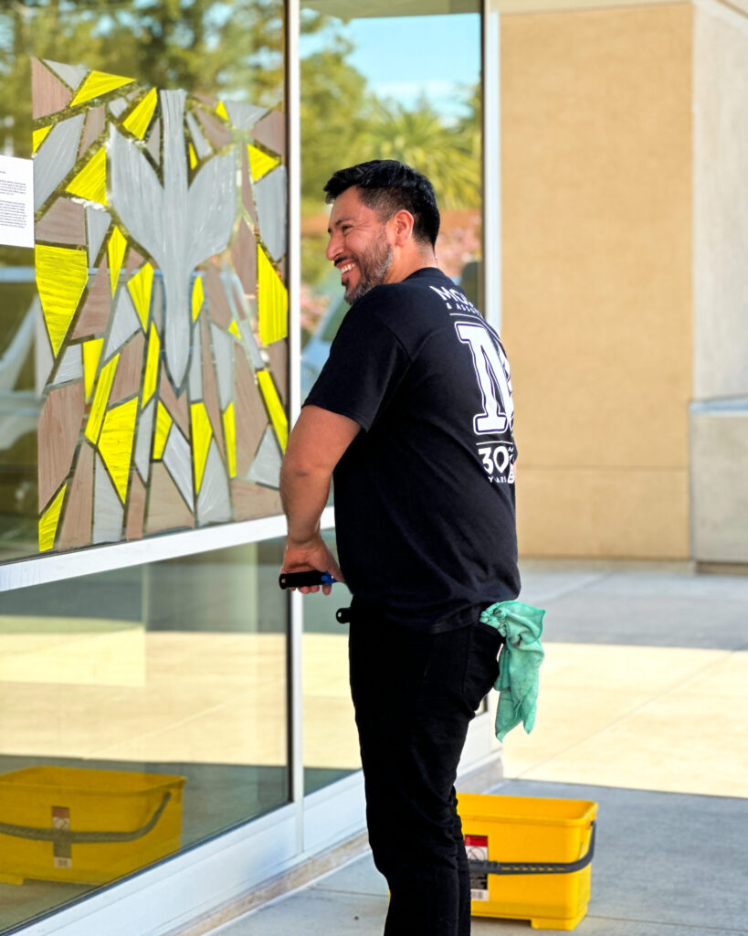 man smiling while preparing to wash a window