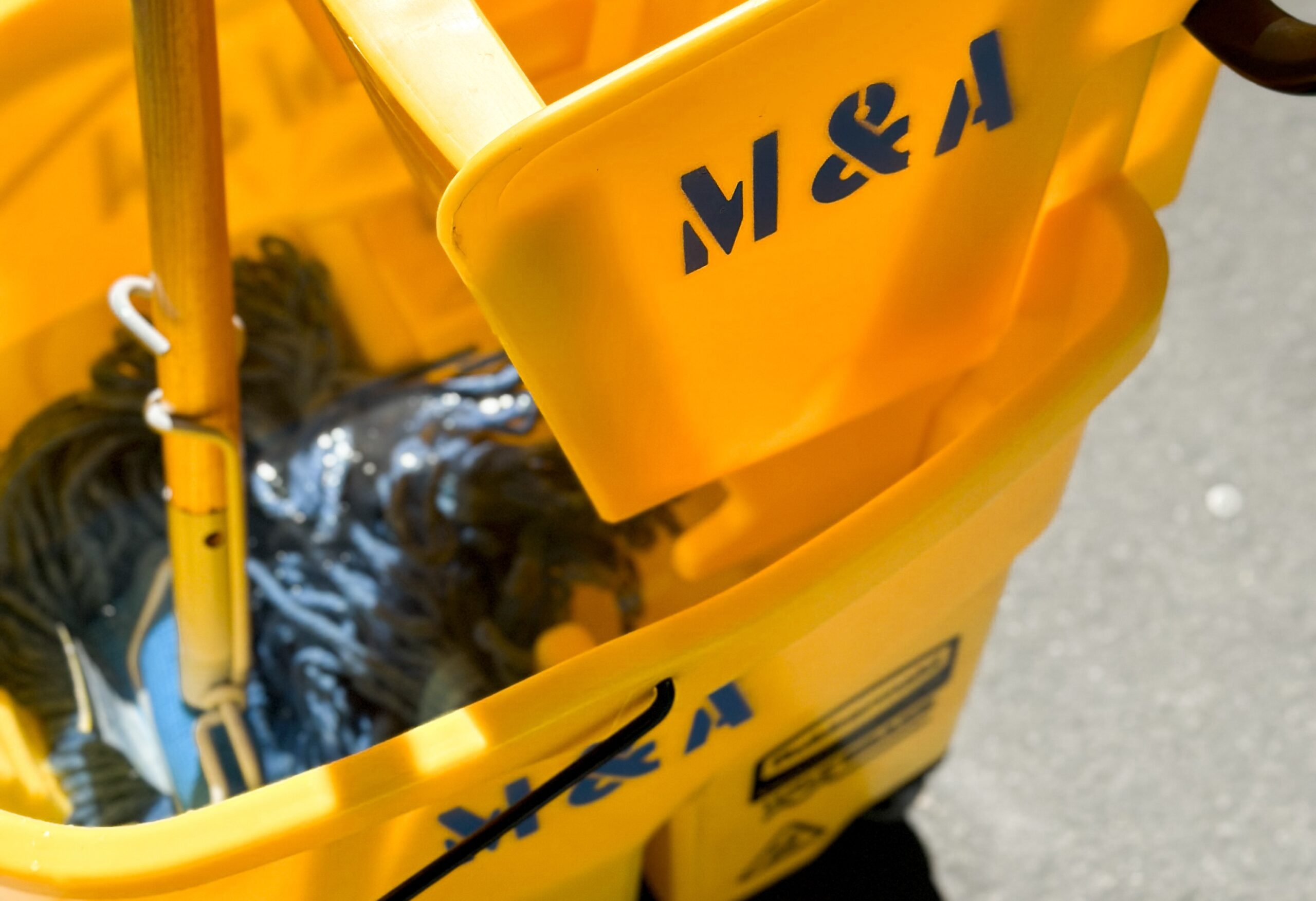 close up photo of a janitors mop and bucket